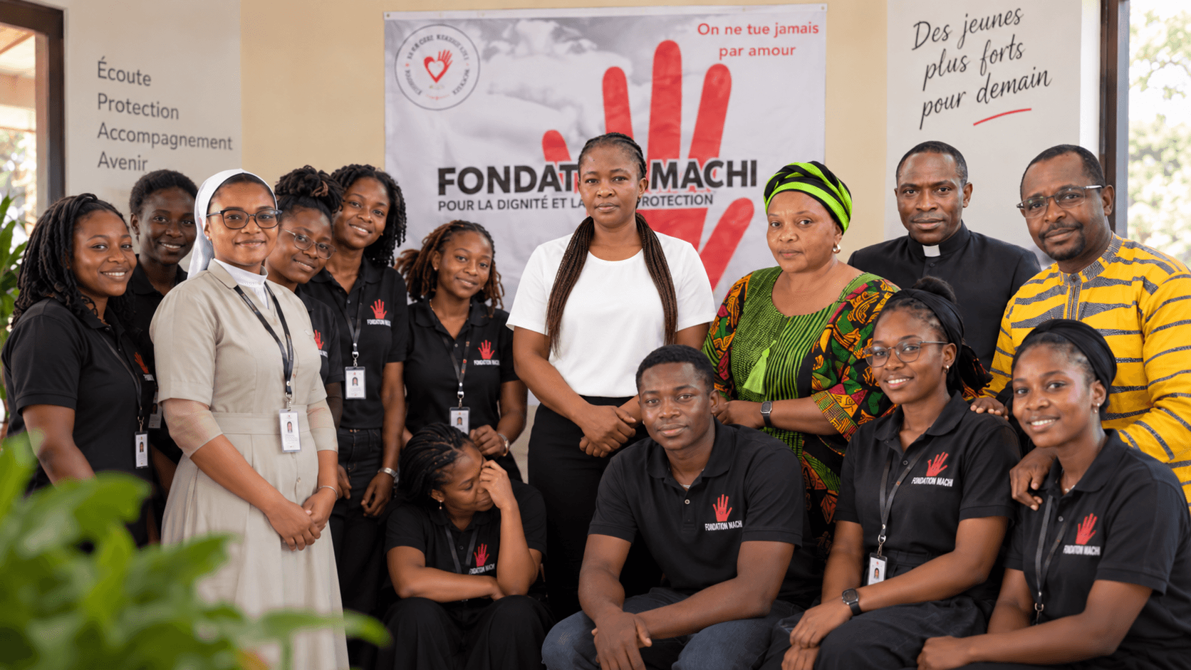 L'équipe de Fondation Machi réunie devant une banderole de la Fondation, en tenue de terrain.